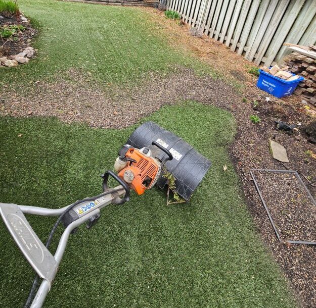 Power broom machine cleaning and lifting artificial grass fibres during maintenance