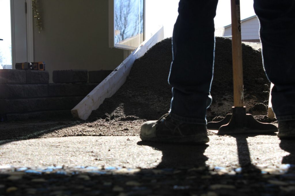 Installer compacting gravel base prior to artificial turf installation